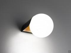 Minimalistische Dew-Lampe in der Version als Wandleuchte, Außenstruktur aus mattschwarz lackiertem Metall, Innenseite aus blattvergoldetem Metall