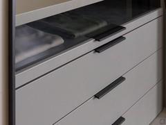 Detail einer Kommode mit erster Schublade mit Rauchglasfront