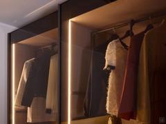 Detailansicht der Schiebetüren aus transparentem grauem Glas – die Innenbeleuchtung mit vertikalen LED-Leisten, die in die Seitenwände eingelassen sind, kommt besonders gut zur Geltung.