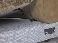Detail, wie die Sitzkissen an der Schale befestigt sind und wie sie mit einem rutschfesten Stoffbezug versehen sind, damit sie nicht nach vorne rutschen