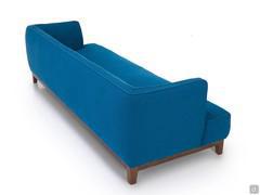 Rückansicht des Sofas Goya. Die weiche, aber kantige Rückenlehne ist vollständig verarbeitet, wodurch das Sofa ideal für die Positionierung in der Mitte des Raumes ist.