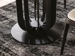 Auf dieser Aufnahme sieht man den massiven Metallsockel in elliptischer Form, mit vertikal ansteigenden Linien, die den Deckel zart stützen 