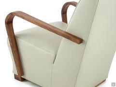 Detail of the curved solid wood armrest, subtle and minimal compared to the volume of the upholstered armchair