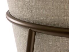 The tubular armrests of the Maggie armchair encircle the backrest, creating a subtle metal structure perfect for industrial chic settings