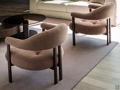 Detail of the back of the Greta armchair, with the upholstered and covered backrest grafted into an embossed metal frame in different colours