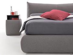 Detail of the high bed frame with soft shapes and generous volumes