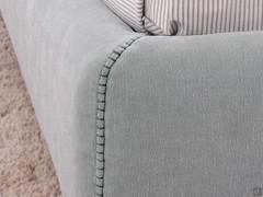 Detail of fabric bed frame cover finished with horse stitching (closed embroidery)