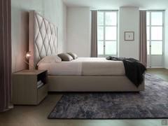 Side view of upholstered bed with quilted headboard Olivier