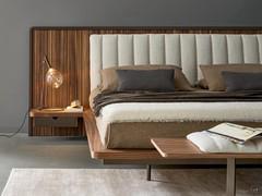 Detail of bed frame, headboard and side bedside table made of canaletto walnut wood