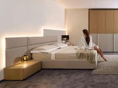Freeport double bed in the version with high, upholstered bed frame, completed by upholstered, matt lacquered panelling and Mason bedside tables
