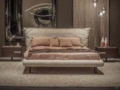 Bed with Pascal fabric and leather headboard by Cattelan, with the upholstery of the bed-ring taking up the back. This feature makes it ideal also for centre-stay positioning