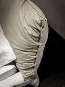 Detail of the bi-covered headboard in leather and fabric, with perimeter stitching separating the two materials