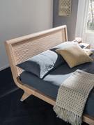 Detail of the all-wood headboard of the Sebastian bed, with its distinctive sculpted, three-dimensional finish