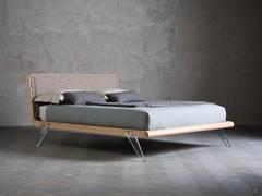 Sebastian bed in the version with upholstered headboard and transparent glass feet