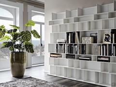 Foreshortened view of a Wally white lacquered bookcase from which one can appreciate the rhythm given to the composition of the vertical partitions