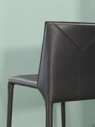 Detail of the leatherwork with visible stitching that becomes a decorative motif on the backrest
