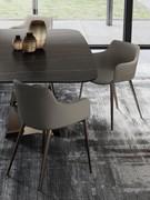 Back and side view of the Count armchair with armrests, here proposed with leather-covered shell and bronze-painted metal legs