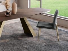 Side view of the Bell designer lounge chair from which one can appreciate the generous upholstery and silhouette of the seat and backrest. Champagne-painted metal legs and upholstery in stain-resistant Venice fabric