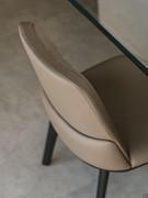Detail of the backrest of the Belinda chair without armrests and the characteristic stitching of the leather upholstery