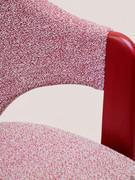 The end of the armrest interrupts the upholstery leaving space for the wood and joins directly to the lower part of the seat