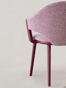 The curved back develops laterally away from the seat, delineating an 'empty' space enclosed by the armrests