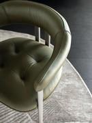 Detail of the leather seat of the Greta chair, with quilting and visible stitching. Also available upholstered in fabric or imitation leather