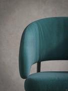 Detail of the thick upholstery of the Shelter chair, specially designed to guarantee a high degree of comfort. Also visible is the special curvature of the backrest and armrests