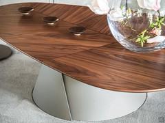 The generous shapes of the conical base in embossed titanium blend with the sober but irregular geometry of the top with bevelled edges