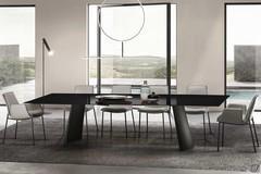 View of the Edwin fixed table with sail-shaped base from the front. Rectangular tabletop in glossy-black painted glass and base in Black painted metal.