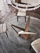 Detail of the base in Brushed Bronze finish on a round Skorpio table with glass top