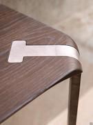 The curvature of the end of the legs follows perfectly the rounding of the corners of the solid wood top. Also noticeable is the minimal thickness of the top due to the special processing of the edges