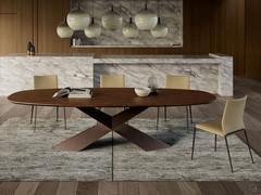 Tyron table in the barrel-shaped version in Canaletto Walnut, with bronze-embossed metal frame