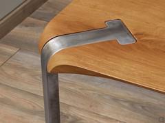 The surfaces of the solid oak top and the cold-curved steel legs are perfectly coplanar and follow the bevel at the four corners of the top