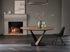 Wood and metal table with central Fortaleza base. Ø160 cm fixed round model in solid walnut. Inclined edges, black painted metal base and walnut inserts