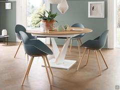 Extendable round Fortaleza table. The white-painted metal base conceals the central folding extension in the underside