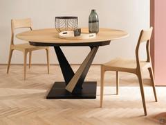 Fortaleza round table extendable from cm 147 to cm 207. Top in Kuba oak, base in black painted metal. Matching the table we see the Paloma chairs in Alaska oak