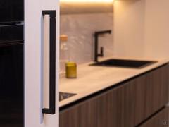 Close up of the black rubberized handle that opens the folding doors of the KLab Exedra concealed kitchen