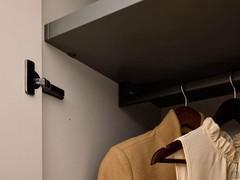 Detail of coat rail in Umber Shine finish, with lacquered shelf and sides in Skin Effect NSE melamine. The interiors of the Driver Wide wardrobes are customisable not only for accessories, but also for finishes
