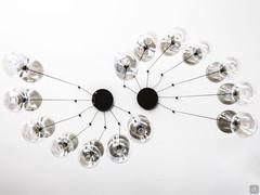 From the two black chrome-plated metal ceiling attachments, 7 lampshades on each side branch out respectively, creating a feeling of movement 
