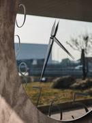 Detail of the mirrored surface of the Moment clock by Cattelan, available in transparent mirrored glass or smoked effect