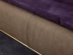 Bed frame upholstered in leatherette, combined with bronze metal base