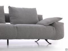 Detail of the generously proportioned seat with low armrest accompanied by an upholstered cushion