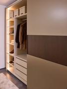 View of the accessories in one of the two compartments of the wardrobe illuminated by a vertical LED bar and organised with drawers, hanging tube and numerous shelves