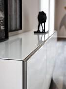 Detail of the door with a titanium-embossed metal profile and an applied sheet of extra-clear white glass. The top is also covered with a crystal plate to match the doors