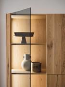 Detail of smoked grey glass door, wooden shelves and side panel with integrated LED, features of the Pilar showcase