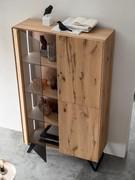 Pilar sideboard in the tall cabinet version, with one grey smoked glass door and two wooden hinged doors to match the structure. The side with integrated LED light is always included