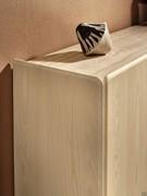 Detail of the intersection between the sides and doors of the Menhir sideboard, with the special rounded edge workmanship common to all the structural elements of the cabinet