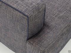 Detail of the armrest finished on the side with a raised profile and the hammerhead seat cushion covering the front