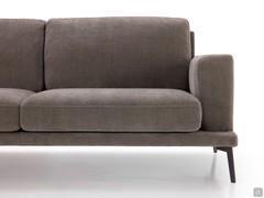 Front detail highlighting the relationship of shapes and volumes of the floor, armrests and cushions, together with the pleasant 'suspended effect' given by the slender anthracite-painted metal sloping feet