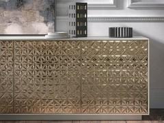 Détail des motifs floraux du buffet. Les reliefs captent la lumière et les formes, les restituant dans des teintes changeantes